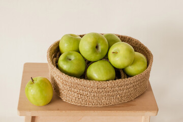 Ripe green juicy apples in a handmade jute basket. Vitamins, healthy wholesome food, fruits