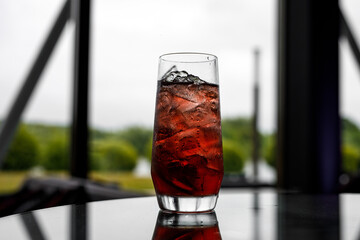 Glass of red lemonade with ice.