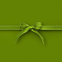 merry christmas gift card with green fabric ribbon bow isolated on green background, top view and...