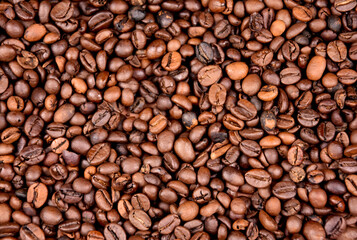 Pile of roasted coffee beans top view close-up stock images. Many roasted coffee beans texture full frame stock photo