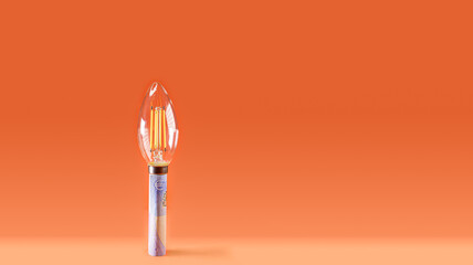 Led bulb on a euro bill, symbolizing the rising cost of electricity.