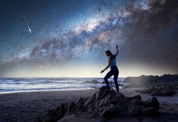 unknown woman standing on the beach with Milky Way background