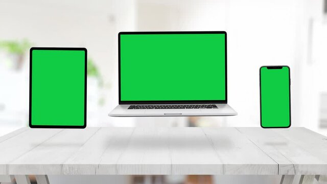 Levitating devices on office desk for responsive web design presentation. Isolated screens in chroma key green for mockup