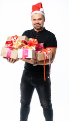 portrait of a man in a black t-shirt, jeans and santaclaus hat in the studio. italian macho holds a lot of gifts and looks at us. donation for the new year birthday holidays. isolated white background