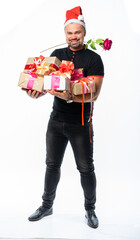 portrait of a man in a black t-shirt, jeans and santaclaus hat in the studio. italian macho holds a lot of gifts and looks at us. donation for the new year birthday holidays. isolated white background