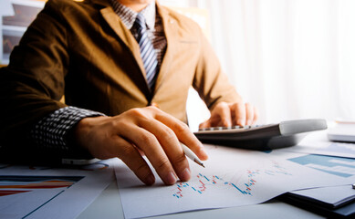 Financial Businesswomen analyze the graph of the company's performance to create profits and...
