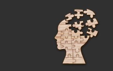 Mental health symbol. Human head silhouette with a puzzle cut out from wooden background