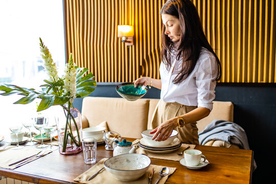 arabic designer etiquette teacher showing how correct set a dishes in a restaurant
