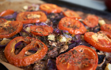 Pizza with baked tomatoes on top