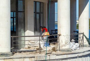 Restoration or renovation of the facade of an old building. A worker builds or repairs a residential building.