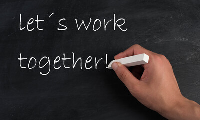 Lets work together is standing on a chalkboard, handwritten with white chalk