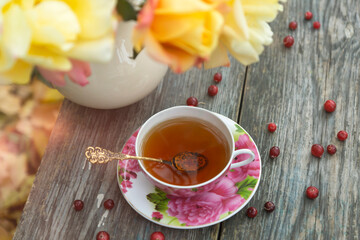 Tea in a beautiful cup and cranberry marmalade in the autumn garden.