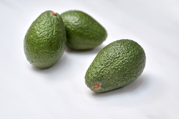 three avocados on a white background