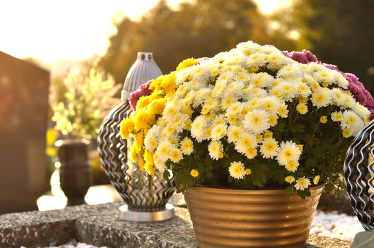 Gravelights  and chrysanthemums on the grave on All Saints' Day