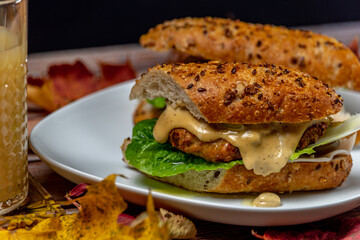 Chicken burger in seeds baguette with olive jalapenos dressing with pear juice