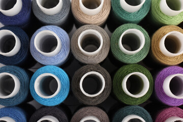 Set of colorful sewing threads as background, top view