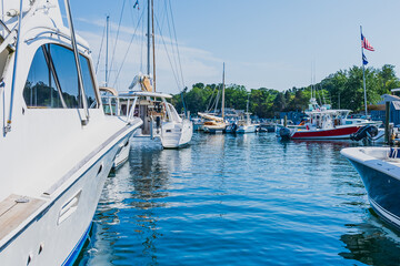 Fototapeta premium Boats and yachts in the port. In the center of the photo, the blue sky is reflected in the blue water