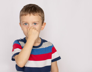 Little boy, holding his nose because of a bad smell
