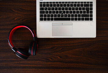 Laptop y audifonos inalambricos sobre un escritorio de madera, oficina de trabajo para call center,...