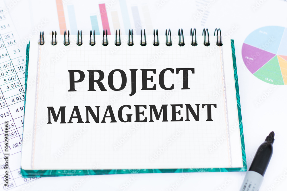 Poster project management written in a notebook on the background of diagrams near a black marker