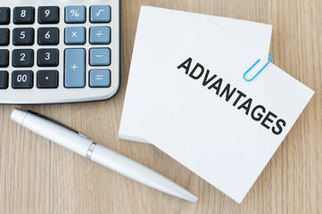 Advantages symbol. Concept word 'advantages' on white note on wooden table. Business and advantages...