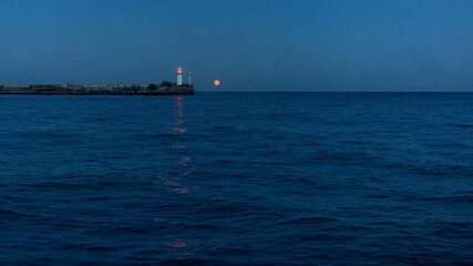 Obraz premium Night view of the lighthouse and the moon