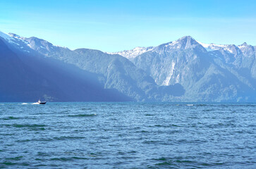 small boat sailing between mountains