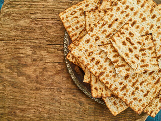 Minimalistic composition - a stack of traditional Jewish Easter bread matzah on a wooden background. High angle view. Jewish Passover, religion, Judaism, kosher food.