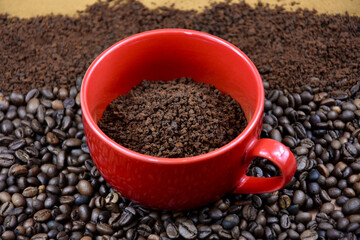 Red mug with roasted coffee beans stock images. Pile of roasted coffee beans and ground instant coffee stock images