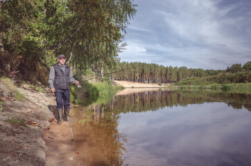 Fototapeta na wymiar Fisherman on the bank of a beautiful river.