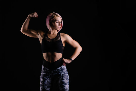Stylish sports Black background. Sport modern woman exercising strong with muscles. fitness banner. Workout gym. Girl powerful in sportswear. Bodybuilding. Pink hair. fitness motivation