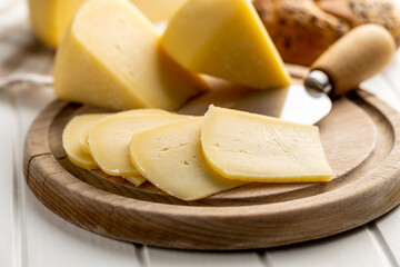 Block of hard cheese. Sliced cheese.