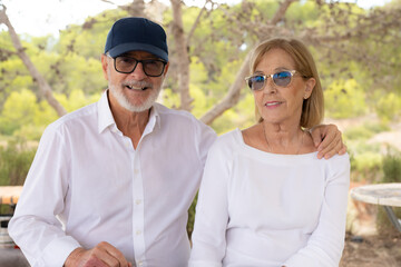 Happy old couple smiling in a park on a sunny day