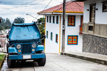 Fototapeta na wymiar Traditional off-road vehicle parked at a beautiful street in the small town of Salento located at the region of Quindio in Colombia