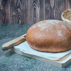 a round loaf of sliced wheat bread with a baked shiny crust on the kitchen table