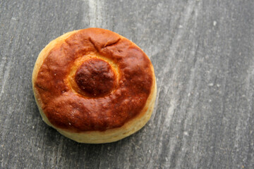 Fresh, delicious and freshly made sweet bisquet bread ready to eat on a wooden table with a colored napkin accompanied by hot coffee for breakfast
