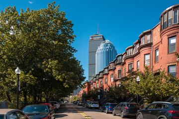 Boston city street landscape with red brick buildings, cars, and skyscrapers on West Newton Street