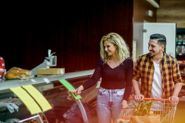 Couple in a supermarket with shopping cart while grocery shopping