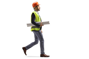 Site engineer with a safety equipment walking and carrying blueprints