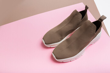 modern beige sneakers with white soles on multicolour background  - Image