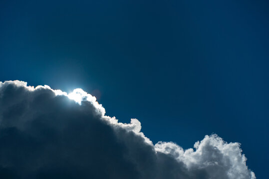 .Download Preview.Share.Add to Likebox.Cloudscape with the sun shining through the clouds in a blue sky.