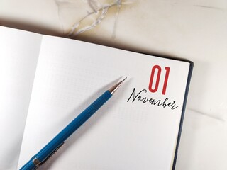 November 01. 01th day of month, pen on the diary on the granite table. Concept of day of year, time planner, autumn month.