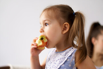 happy cheerful funny kids children with mom eat bite fresh fruits and vegetables at home. family...