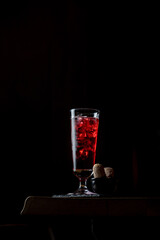 A silhouette of a pink alcoholic cocktail in a black room, upwards photo with beautiful light