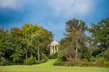 Fototapeta na wymiar Woerlitzer Park Venus Temple behind trees and cloudscape