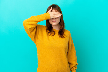 Redhead girl isolated on blue background covering eyes by hands. Do not want to see something