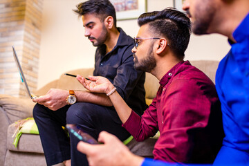 friends from india looking something interesting on laptop in livingroom