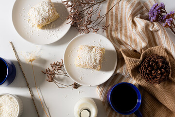 Fototapeta na wymiar Breakfast beige cozy composition with coconut cake. Flat lay, top view