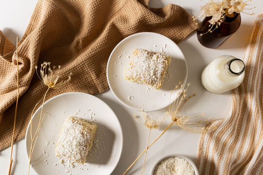 Breakfast beige cozy composition with coconut cake. Flat lay, top view