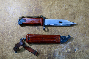 Bayonet knife from AK-47 Kalashnikov assault rifle. Combat knife on wooden background.